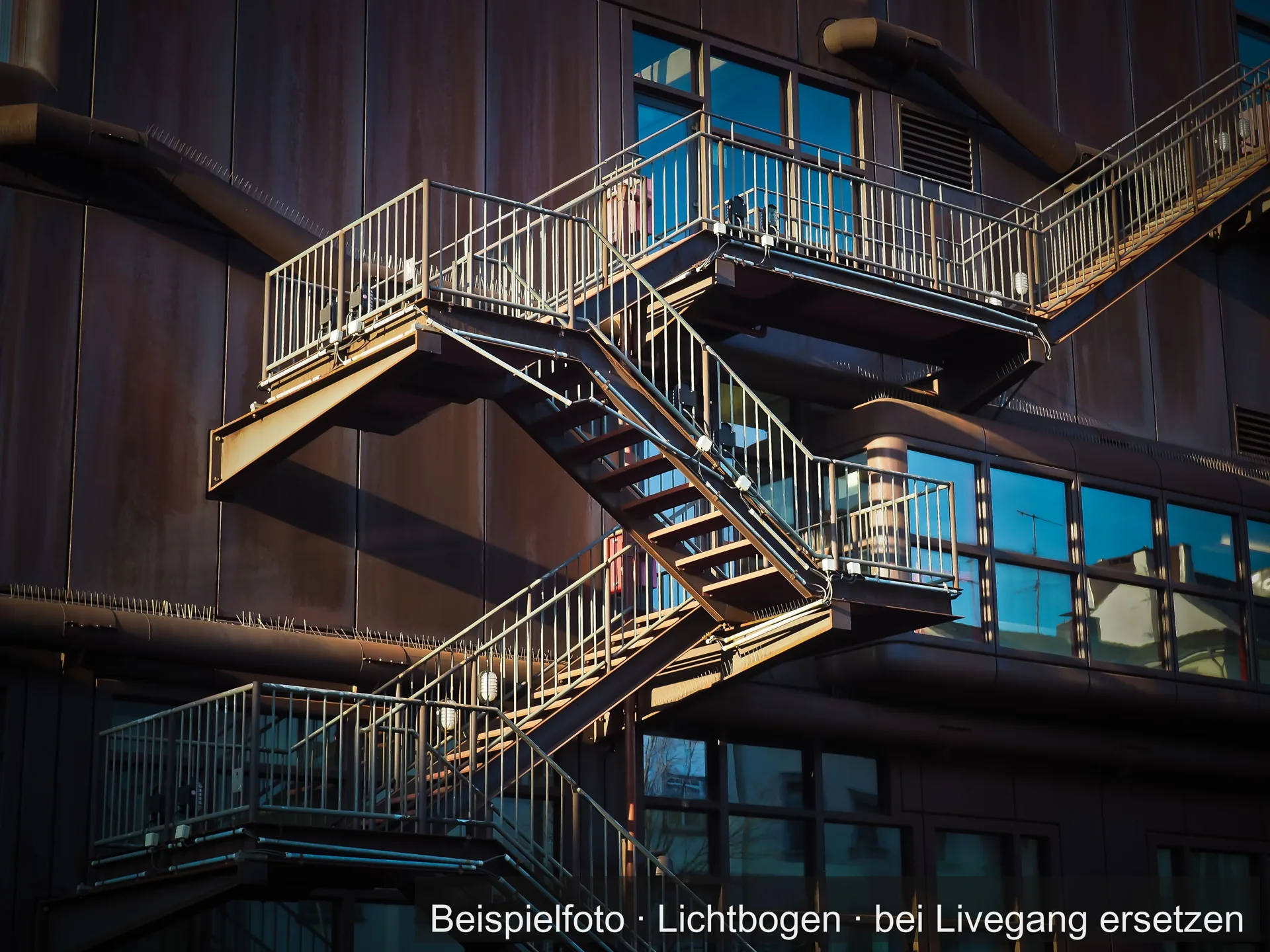 Eine Stahltreppe mit Podesten an einer Gebäudefassade.