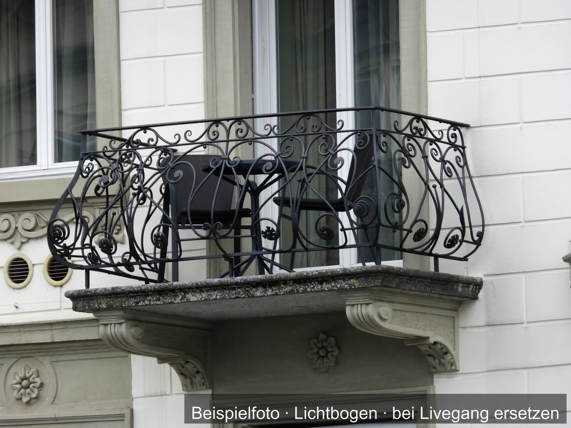Ein Balkon aus Metall an einem Haus.